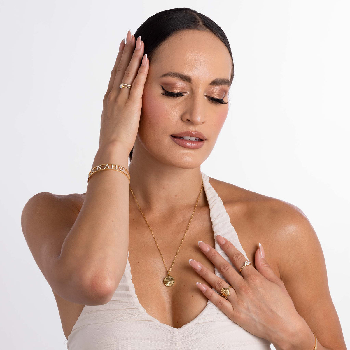 Model wearing 3D Name Stones Bangle in gold, personalized with a name, showcasing elegant jewelry style.